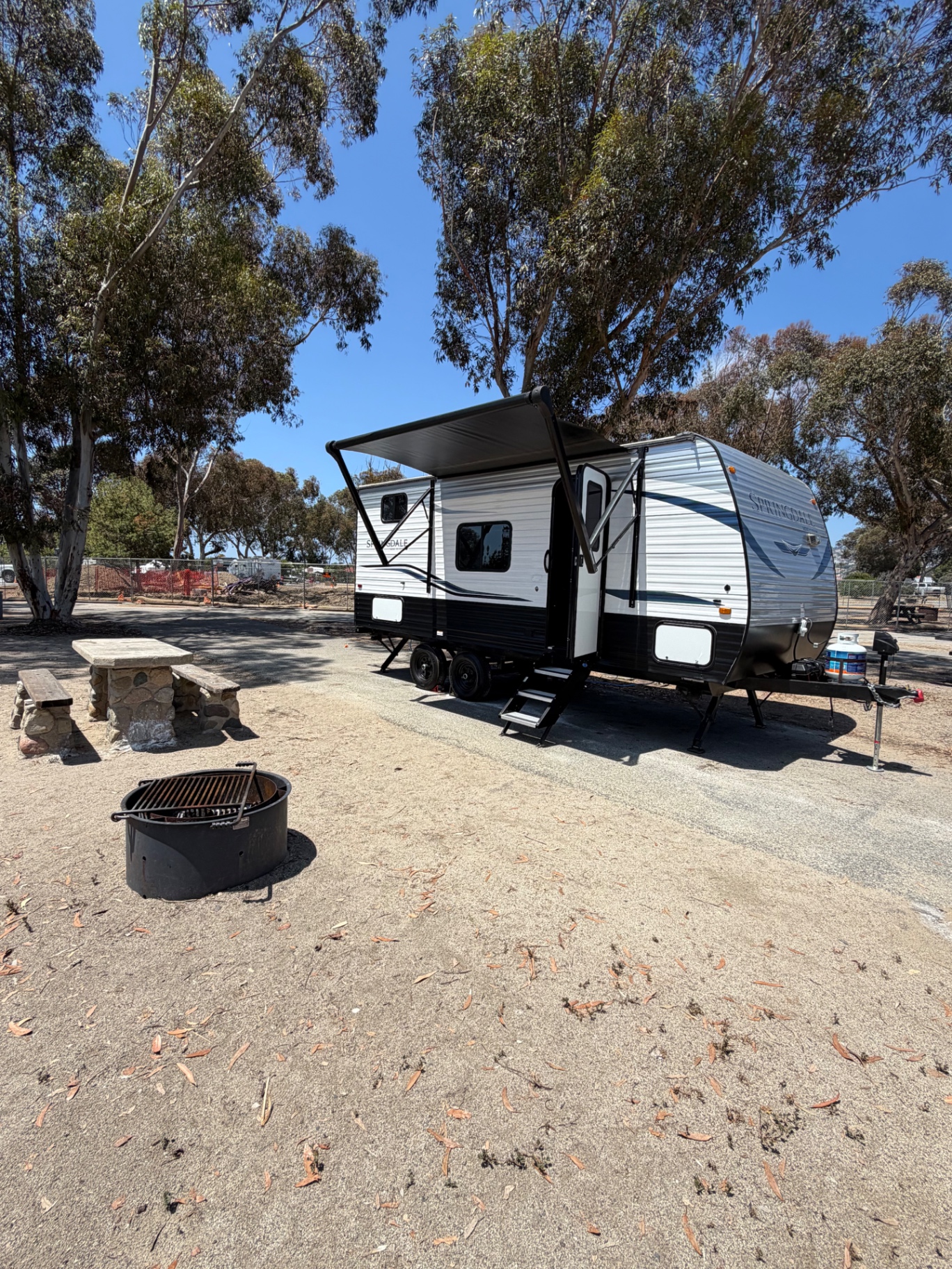 Keystone Springdale Mini set up at a campsite with the awning open